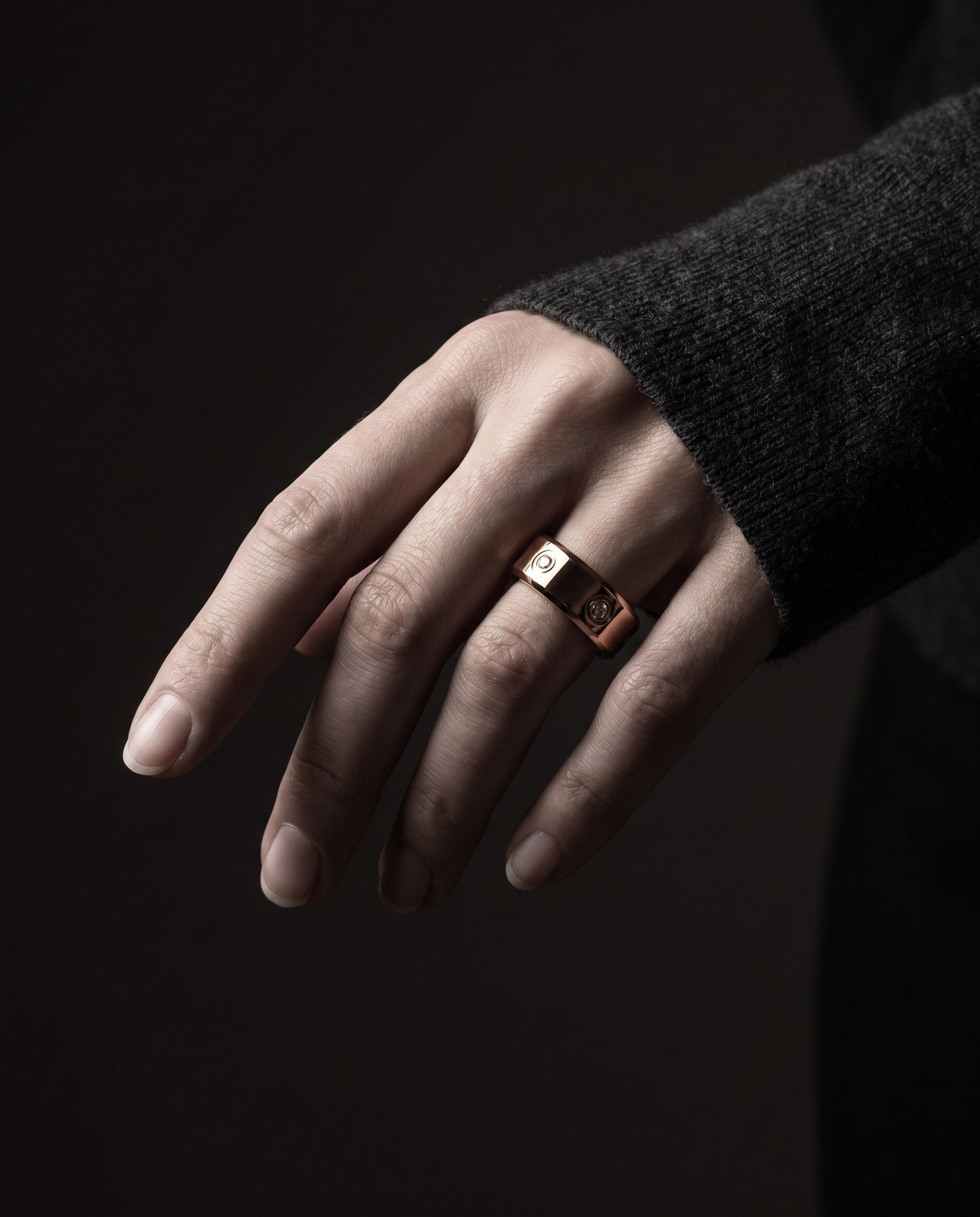The LuxenX ring worn on the index finger, low-key studio portrait of a hand